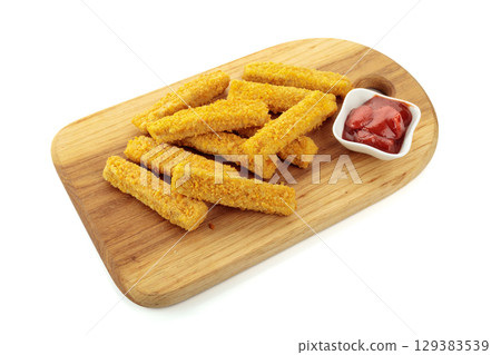 Crispy fried fish fingers ketchup on a wooden cutting board. 129383539