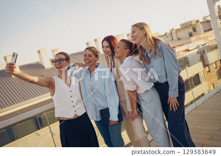 A group of close friends happily enjoying a beautiful sunny day together on a rooftop 129383649