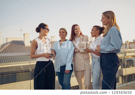 A Diverse Group of Accomplished Professional Women Engaging in Networking Activities on a Rooftop 129383650