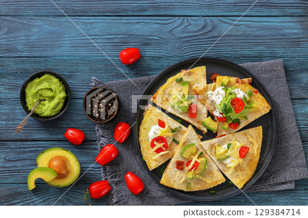 quesadilla with cheese, bacon, avocado on a plate quesadilla with cheese, bacon, avocado on a plate 129384714