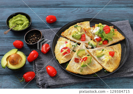 quesadilla with cheese, bacon, avocado on a plate 129384715