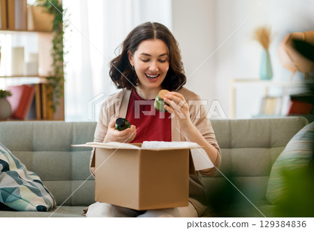Woman is unpacking cardboard Woman is unpacking cardboard 129384836