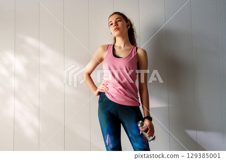 Woman in fashionable sportswear is doing exercise. 129385001