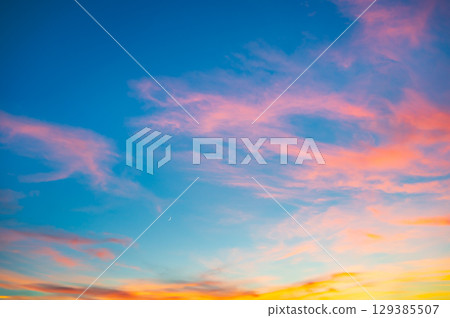 Vivid sunset sky and crescent moon Vivid sunset sky and crescent moon 129385507