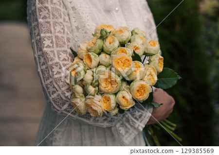Bouquet in female hands. Bunch of Living yellow roses. 129385569