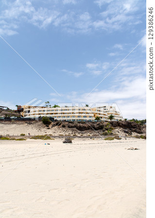 A resort hotel built on a hill along the coast lined with palm trees on Fuerteventura Island A resort hotel built on a hill along the coast lined with palm trees on Fuerteventura Island 129386246