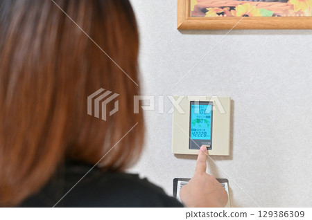 Woman looking at the amount of electricity generated, solar power generation, solar power generation 129386309