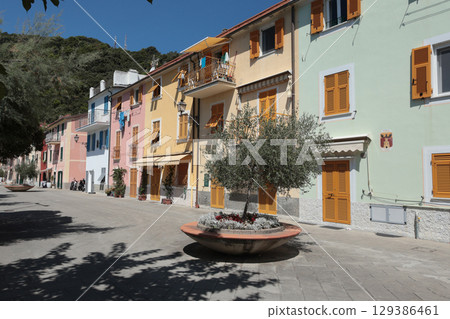 Old street in Italian countryside near sea. Traditional building. Sun day. Entrance, window to house. Nature and sky. 129386461