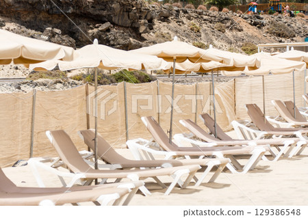 富埃特文圖拉島沿海寬闊的沙灘上擺滿了遮陽傘和沙灘床 129386548