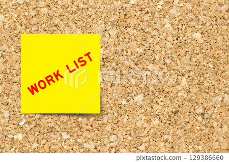 Yellow note paper with word work list on cork board background with copy space Yellow note paper with word work list on cork board background with copy space 129386660