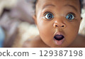 Adorable baby with big eyes and an open mouth - Generative AI 129387198