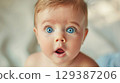Adorable baby with big eyes and an open mouth - Generative AI 129387206