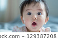 Adorable baby with big eyes and open mouth - Generative AI 129387208