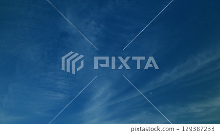 An Exquisite and Majestic Beautiful Blue Sky Filled with Wispy Clouds Calmly Presenting at Dusk Time 129387233