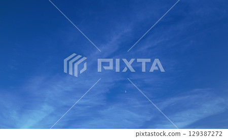 A Beautiful Blue Sky Adorned with Wispy Clouds and a Subtle Hint of the Moon Above A Beautiful Blue Sky Adorned with Wispy Clouds and a Subtle Hint of the Moon Above 129387272