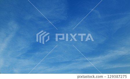 A Beautiful Blue Sky adorned with Wispy Clouds stretches majestically and infinitely above us 129387275