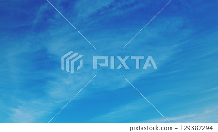 A Beautiful, Serene Blue Sky with Wispy, Fluffy Clouds Floating Gracefully Above 129387294