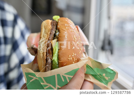 Eating a soul food hamburger (from inside a camper van) Eating a soul food hamburger (from inside a camper van) 129387786