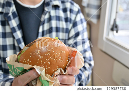 Eating a soul food hamburger (from inside a camper van) 129387788