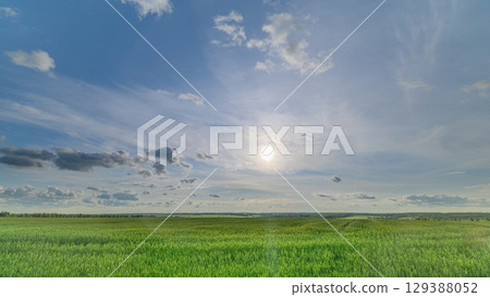 A Serene and Beautiful Landscape Featuring Lush Green Fields Under a Bright Blue Sky 129388052