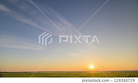 A Serene Sunrise Over Vast Green Fields in the Morning Light That Inspires Peace and Calmness 129388729