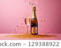 Champagne bottle on pink background with golden glitter on pink background. 129388922