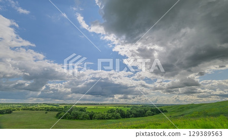 A beautiful scenic landscape featuring dramatic clouds and lush, vibrant green fields A beautiful scenic landscape featuring dramatic clouds and lush, vibrant green fields 129389563
