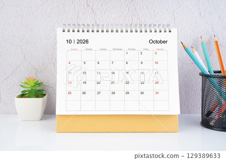 October 2026 Desk Calendar with wooden pencil on white table. 129389633