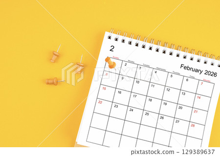 February 2026 Monthly desk calendar for 2026 year with wooden pin on yellow background. 129389637