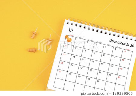 December 2026 Monthly desk calendar for 2026 year with wooden pin on yellow background. 129389805
