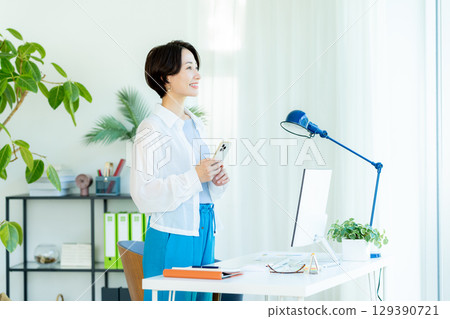 Business woman operating a smartphone in the office Business woman operating a smartphone in the office 129390721