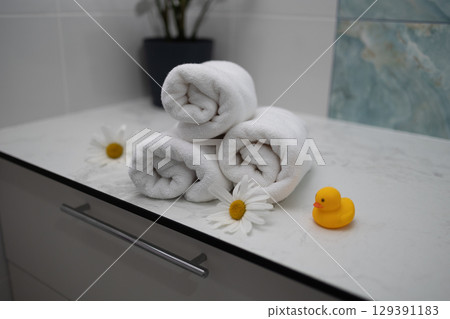 Towels Neatly Arranged With Daisies and a Rubber Duck in a Relaxing Bathroom Setting Towels Neatly Arranged With Daisies and a Rubber Duck in a Relaxing Bathroom Setting 129391183