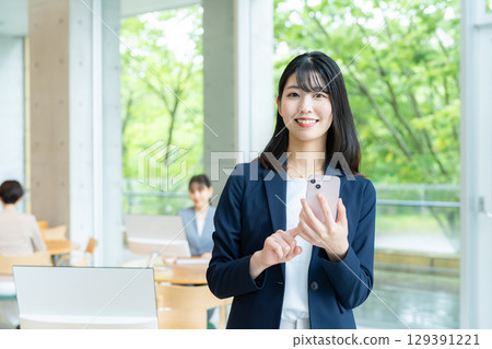 Business woman using a smartphone in the office Business woman using a smartphone in the office 129391221