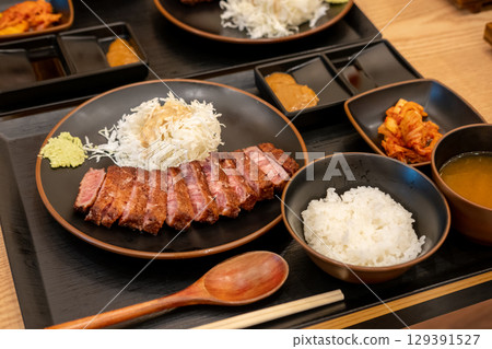 Gyukatsu or beef cutlet. A traditional Japanese food that consists of a deep-fried beef cutlet. served with vegetable Gyukatsu or beef cutlet. A traditional Japanese food that consists of a deep-fried beef cutlet. served with vegetable 129391527