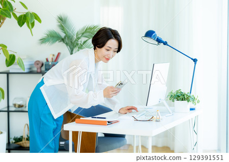 Business woman operating a smartphone in the office 129391551