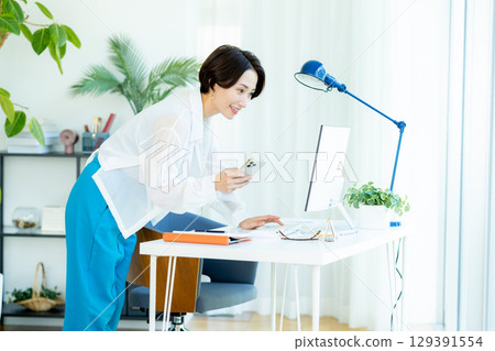 Business woman operating a smartphone in the office Business woman operating a smartphone in the office 129391554