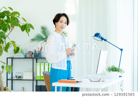 Business woman operating a smartphone in the office 129391565