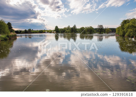 Tranquil Boating lake with perfect sky reflections in Nagykanizsa, Hungary. 129391618