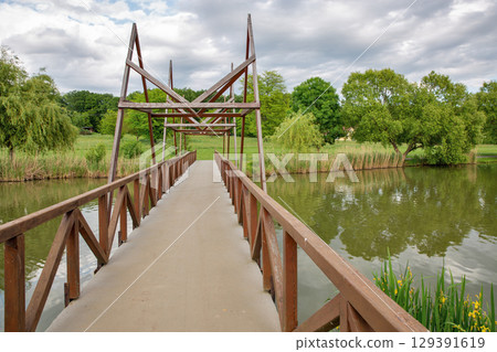 Wooden footbridge over Boating lake in park. Nagykanizsa, Hungary. 129391619