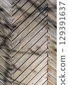 A beautifully crafted Textured Wooden Chevron Pattern showcased in the warm embrace of Natural Light 129391637