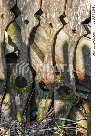 Artistic Wooden Fence Featuring Intricate Designs and Captivating Shadows All Around It 129391640