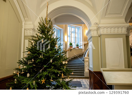Decorated Christmas tree in elegant building interior with staircase 129391760