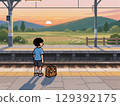 黃昏時分，一個男孩在月台上等火車 129392175