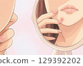A woman checking her facial rash in the mirror 129392202