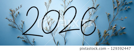 Happy new year 2026 - festive new year party background greeting card with text - Golden yellow fireworks in dark black night. The numbers are written in green fir tree, banner 129392447