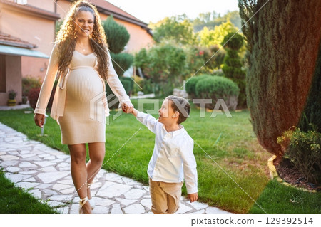 Expecting joy in a sunlit garden with loved ones Expecting joy in a sunlit garden with loved ones 129392514