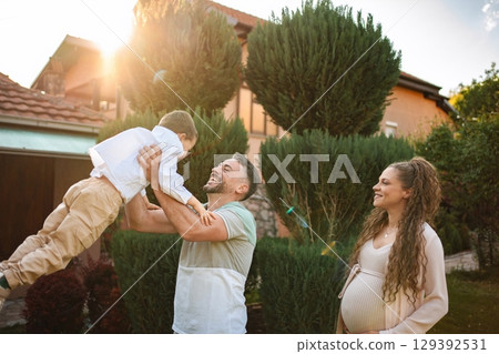 Joyful family moment in the warm evening sunlight Joyful family moment in the warm evening sunlight 129392531