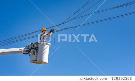 Industry, engineer, construction concept. Work on high voltage supports with lighting. Industrial maintenance engineer in uniform and protective helmet undergoes inspection and testing. 129392598