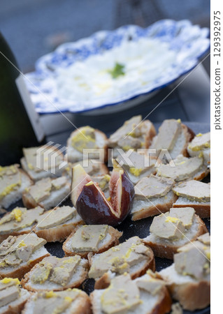 Foie gras and fig toast served as a delightful aperitif in an outdoor setting during a sunny 129392975