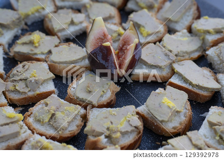 Foie gras and fig toast served as a delightful aperitif in an outdoor setting during a sunny Foie gras and fig toast served as a delightful aperitif in an outdoor setting during a sunny 129392978